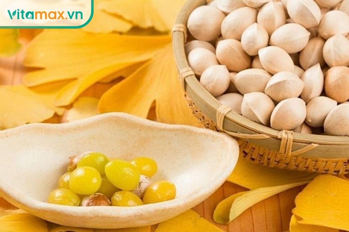 Hạt bạch quả đặt trong giỏ tre cùng những lá bạch quả vàng hình quạt, thể hiện đặc điểm quen thuộc của cây Ginkgo biloba.