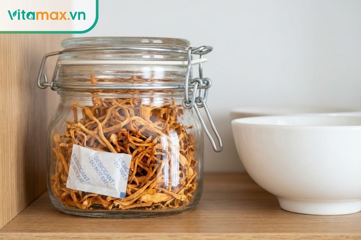 Các hũ thủy tinh nắp kín chứa đông trùng hạ thảo khô được sắp xếp gọn gàng trên kệ gỗ nơi khô thoáng.