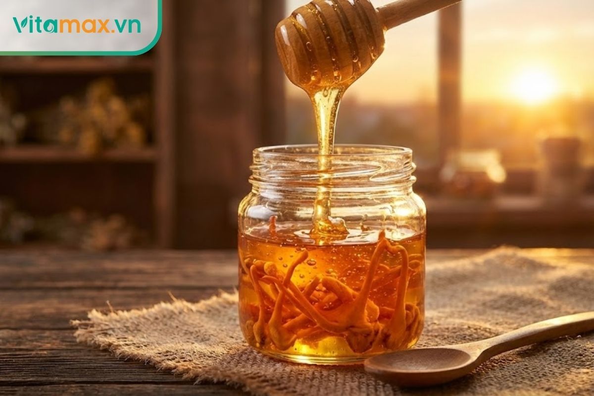 Dòng mật ong vàng óng đang được rót vào hũ thủy tinh chứa đông trùng hạ thảo, tạo nên hỗn hợp dưỡng chất quý.