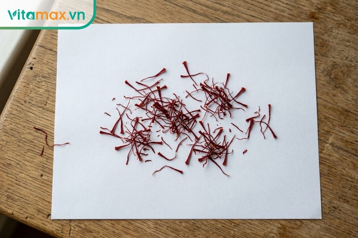 Cận cảnh các sợi nhụy hoa nghệ tây thật nguyên bản có màu đỏ sậm tự nhiên và phần đầu loe to trên nền trắng.