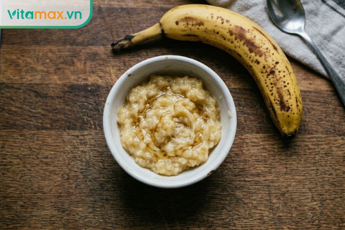Bát sứ đựng chuối chín nghiền nát rưới một chút mật ong nguyên chất, món ăn mềm cho người bị rối loạn tiêu hóa.