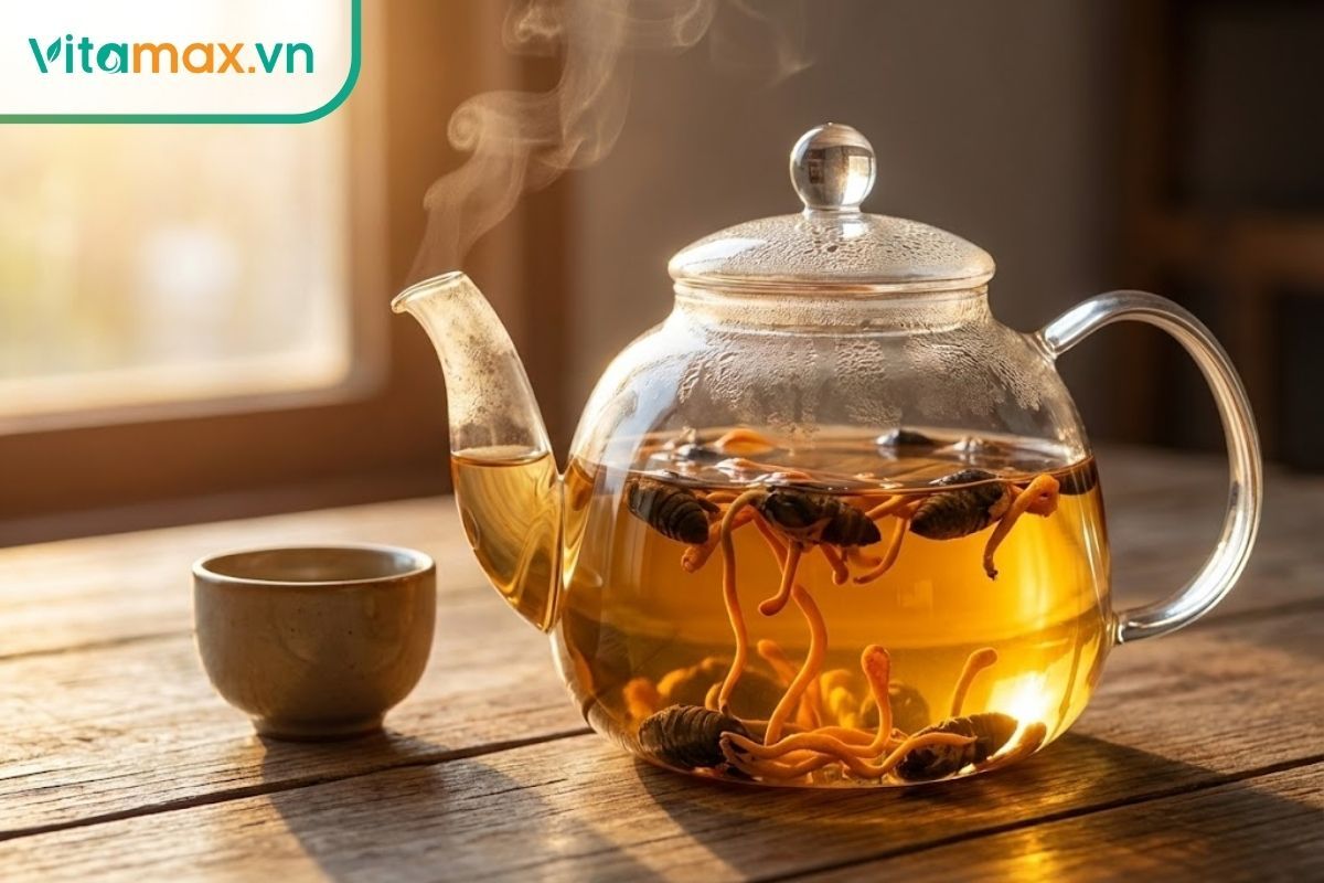 Ấm trà thủy tinh pha đông trùng hạ thảo bọ xít với nước vàng óng, bốc khói nhẹ.