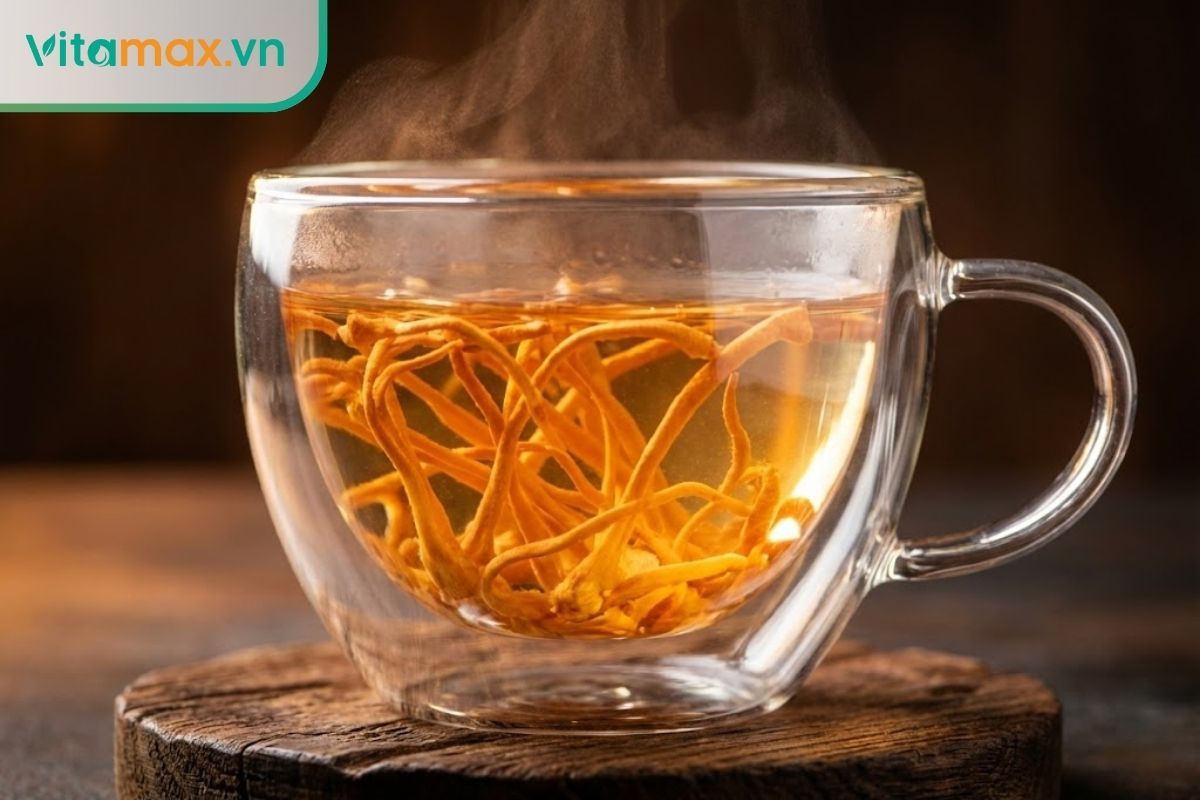Cốc trà đông trùng hạ thảo màu vàng cam đẹp mắt với các sợi nấm được hãm trong nước ấm.