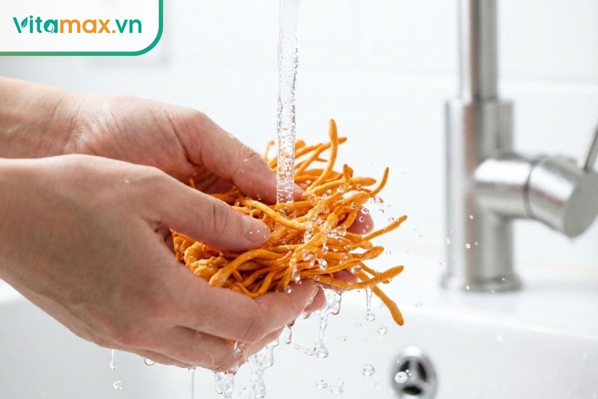 Đôi bàn tay đang nhẹ nhàng rửa sơ sợi đông trùng hạ thảo tươi dưới vòi nước chảy nhẹ.