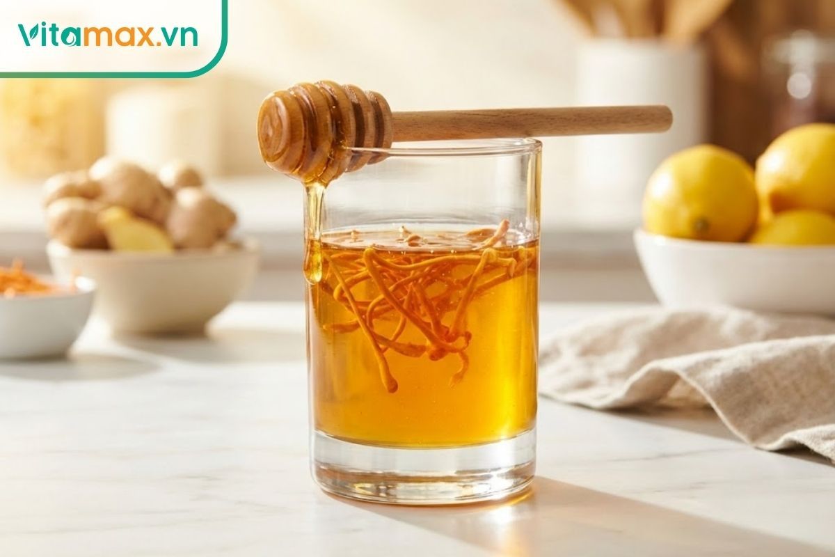 Hũ thủy tinh đựng mật ong nguyên chất ngâm cùng sợi đông trùng hạ thảo vàng óng, đặt cạnh thìa gỗ lấy mật.