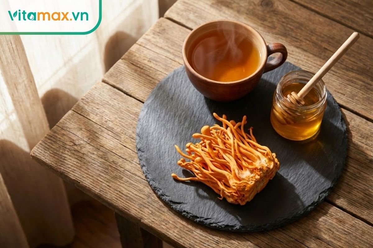 Đĩa nấm đông trùng hạ thảo tươi màu vàng cam rực rỡ bên cạnh tách trà nóng, thể hiện sự tươi ngon và cao cấp.