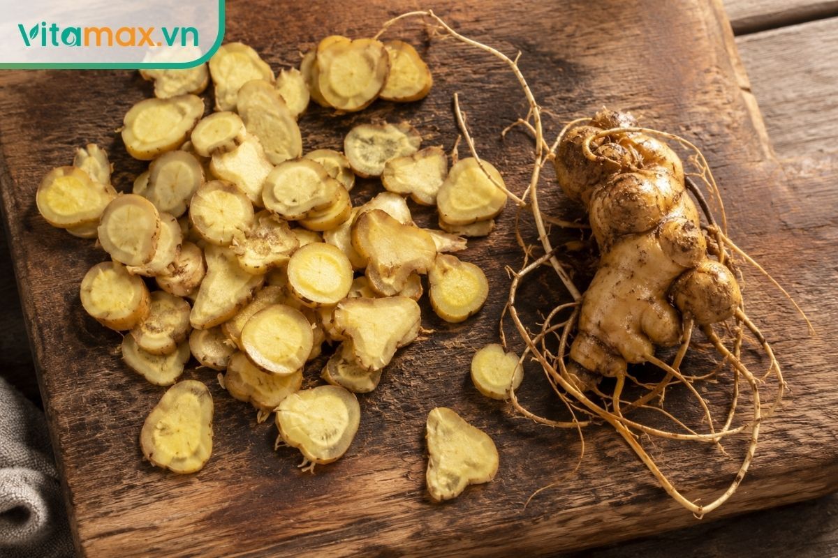 Cận cảnh những lát sâm tươi màu vàng nhạt được thái mỏng đặt trên một thớt gỗ mộc mạc, kế bên là củ sâm nguyên bản còn bám chút đất tự nhiên.
