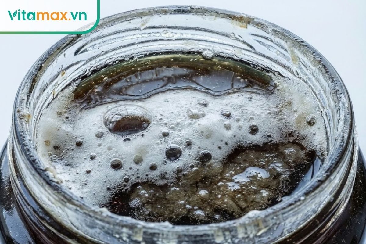 Bề mặt hũ mật ong sủi bọt khí trắng xóa, có dấu hiệu lên men và tách lớp nước.
