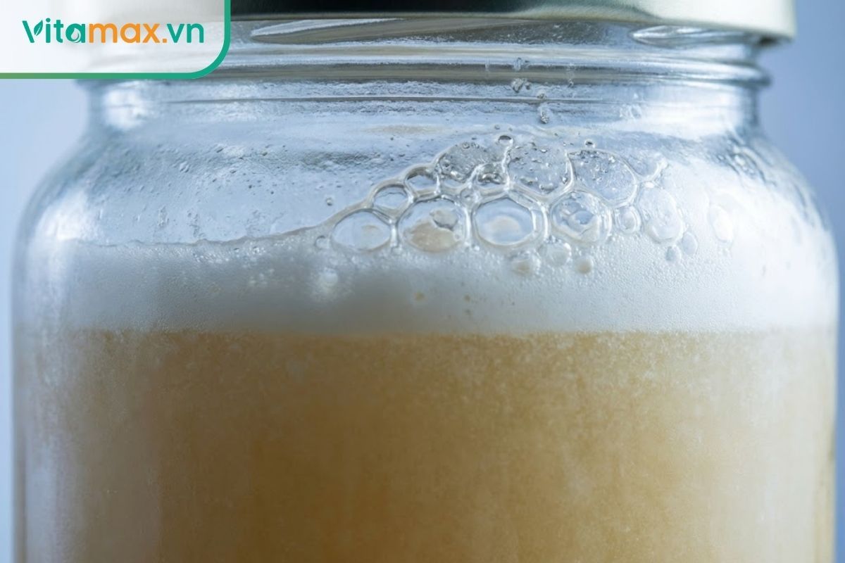 Cận cảnh bề mặt hũ sâm ngâm mật ong nổi nhiều bọt khí trắng dày đặc, dấu hiệu của việc bị lên men và hư hỏng.