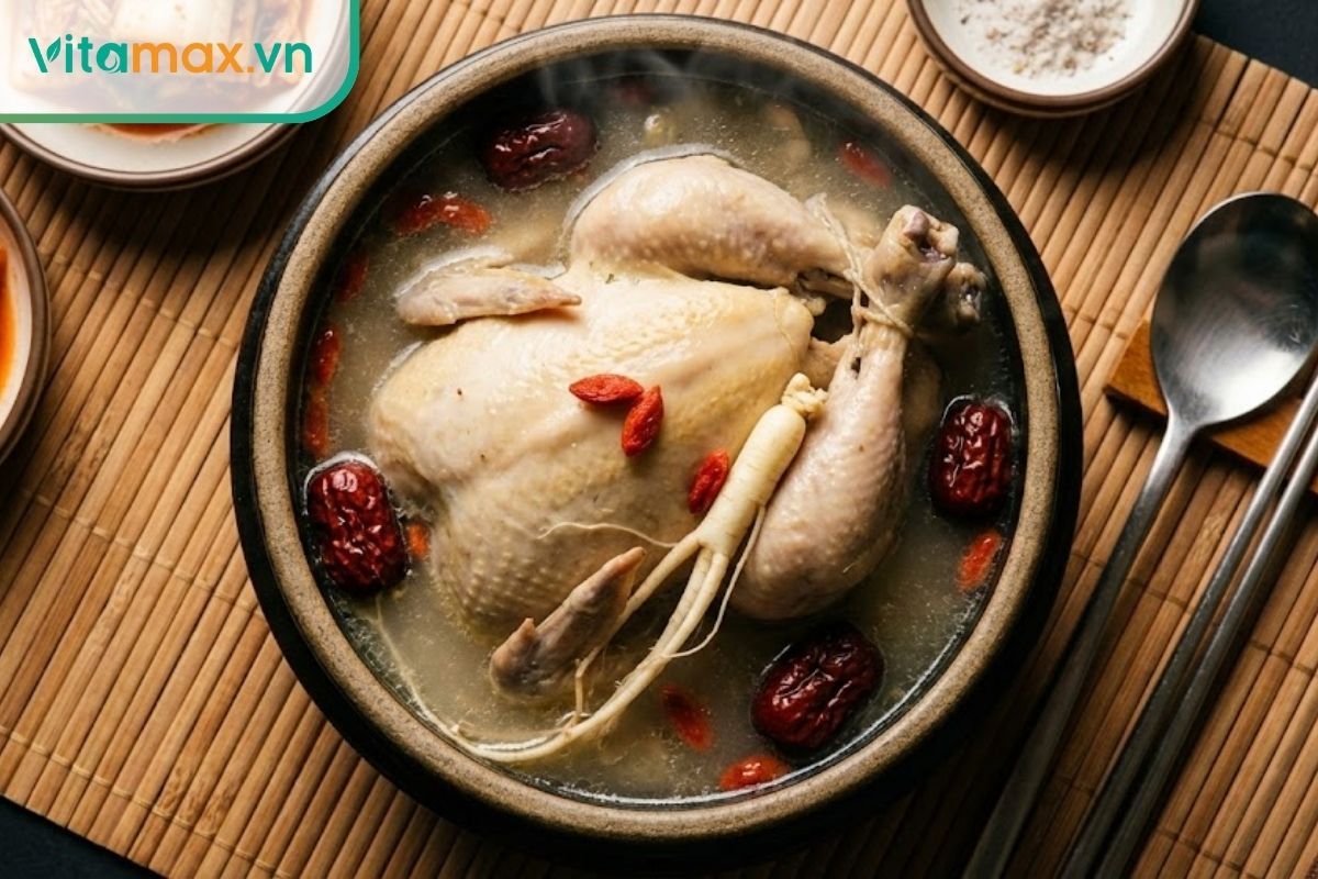 Bát canh gà hầm bạch sâm Hàn Quốc bổ dưỡng, trang trí với táo đỏ và hành lá, món ăn phục hồi sức khỏe.