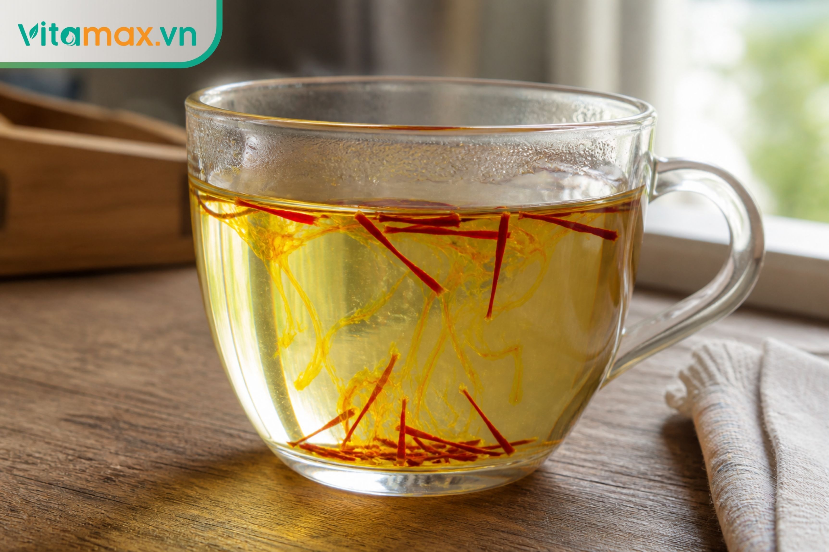Cận cảnh cách pha trà nhụy hoa nghệ tây bằng nước ấm, nước tiết ra màu vàng óng tự nhiên đẹp mắt.