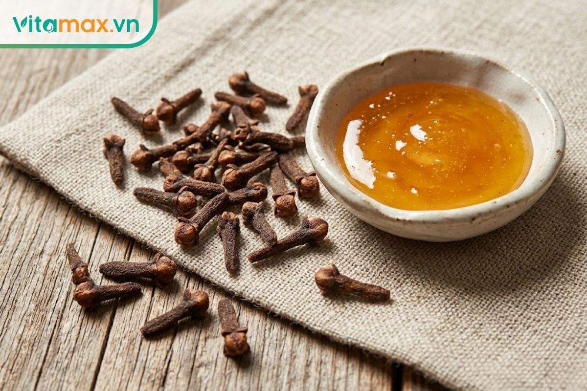 Cận cảnh nụ đinh hương khô thô mộc được giã nhẹ, dùng chung với mật ong để giảm mùi hôi miệng tại chỗ.