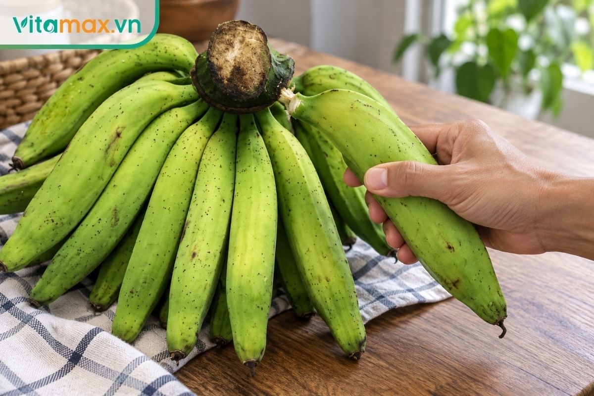 Một quả chuối tiêu lấy từ nải thật, vỏ xanh có gân dọc rõ và chấm tự nhiên, đặt cạnh đĩa nhỏ để minh họa khẩu phần.