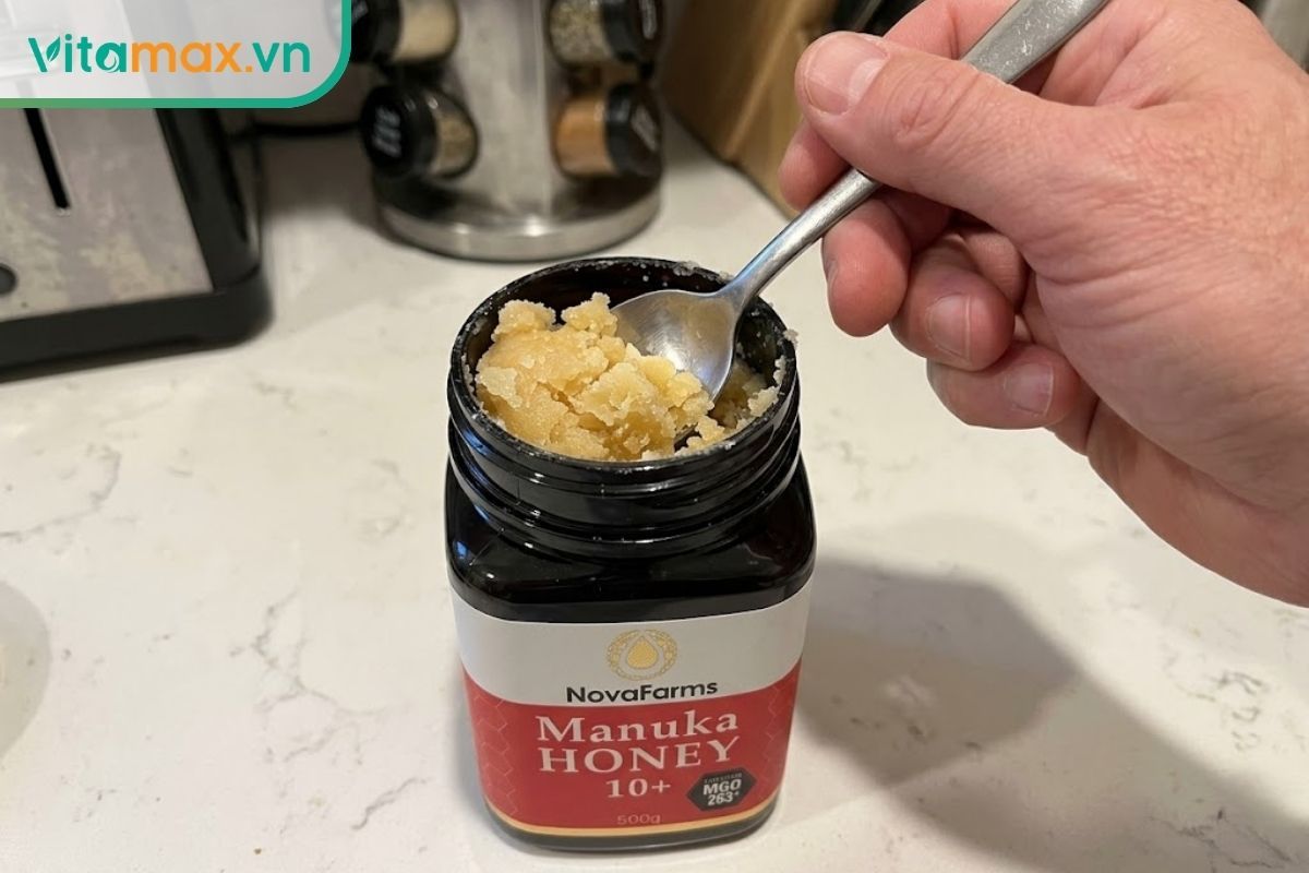 Cận cảnh sự khó khăn khi dùng thìa múc phần mật ong bị kết tinh và đặc cứng do bảo quản trong tủ lạnh.