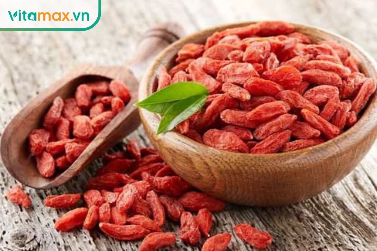 Quả kỷ tử khô màu đỏ được đựng trong bát và thìa gỗ.