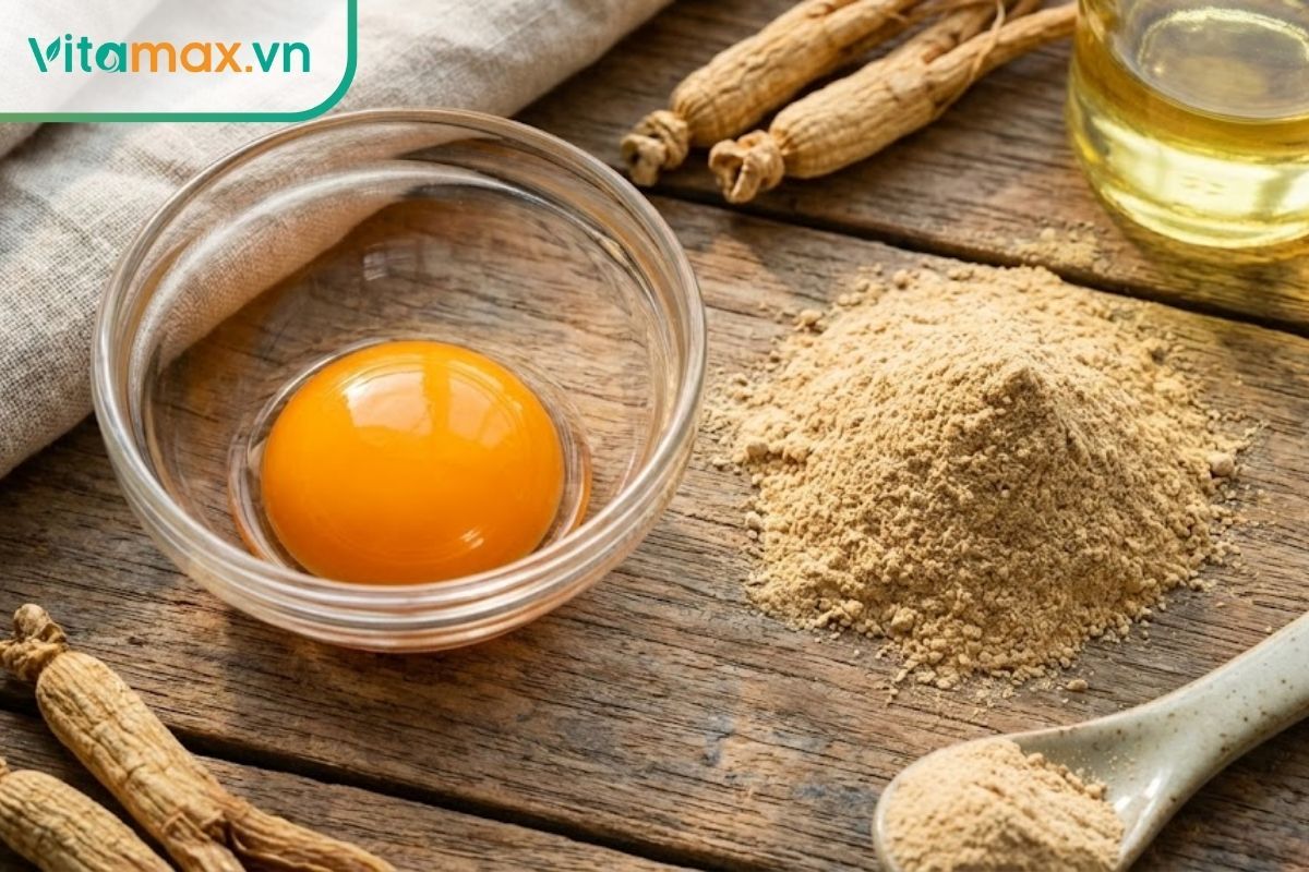 Lòng đỏ trứng gà tươi bóng bẩy nằm cạnh thìa bột sâm khô, thể hiện sự tươi mới của nguyên liệu.
