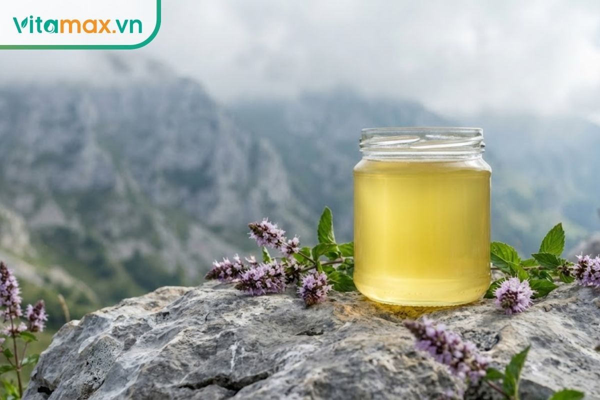 Ly mật ong hoa bạc hà có màu vàng chanh ánh xanh olive đặc trưng, hậu cảnh là cao nguyên đá Hà Giang mờ ảo.