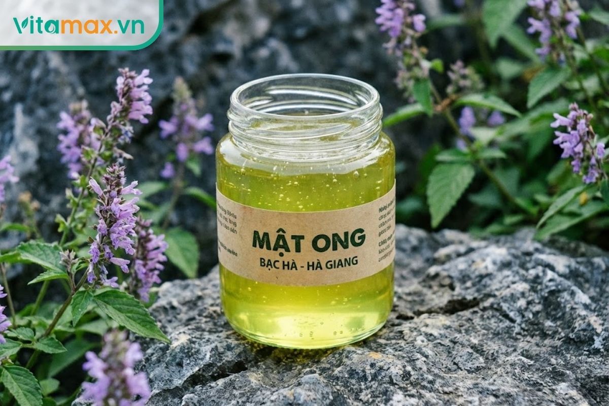 Ly mật ong hoa bạc hà có màu vàng chanh ánh xanh đặc trưng đặt giữa cánh đồng hoa bạc hà tím.