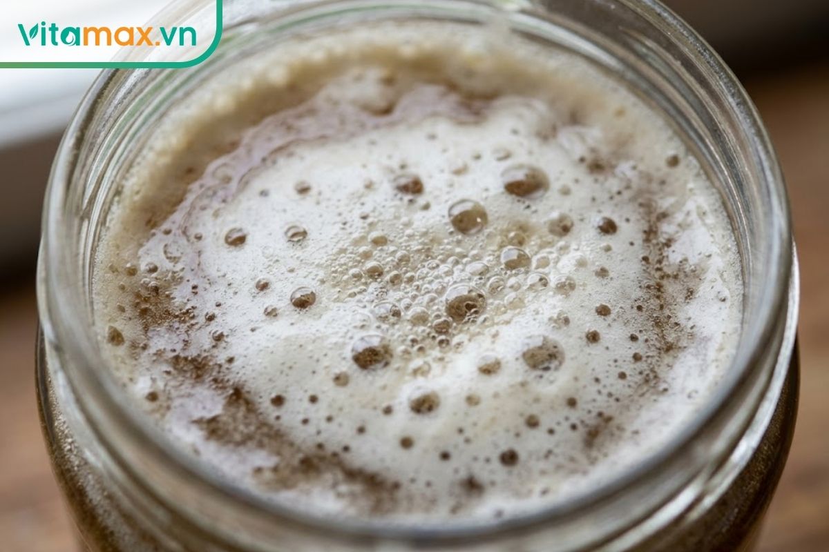 Cận cảnh bề mặt hũ mật ong xuất hiện một lớp bọt trắng dày và các hạt bọt khí li ti nổi lên liên tục do quá trình lên men tự nhiên làm mật bị hỏng.