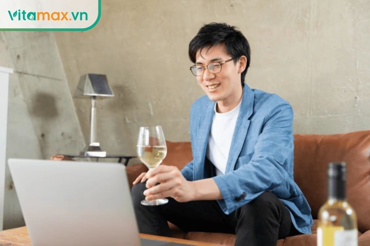 người đàn ông châu Á thưởng thức ly rượu sâm Hàn Quốc tại nhà giúp tăng cường sức khỏe và sinh lực