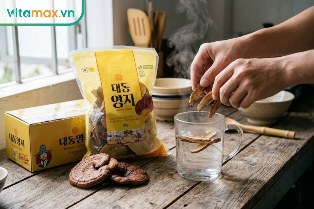 Hộp carton Nấm linh chi Hàn Quốc Daedong (Premium 500g) và gói bao bì đựng nấm nằm trên bàn gỗ mộc, bối cảnh pha trà nấm linh chi đời thực bốc hơi nhẹ.