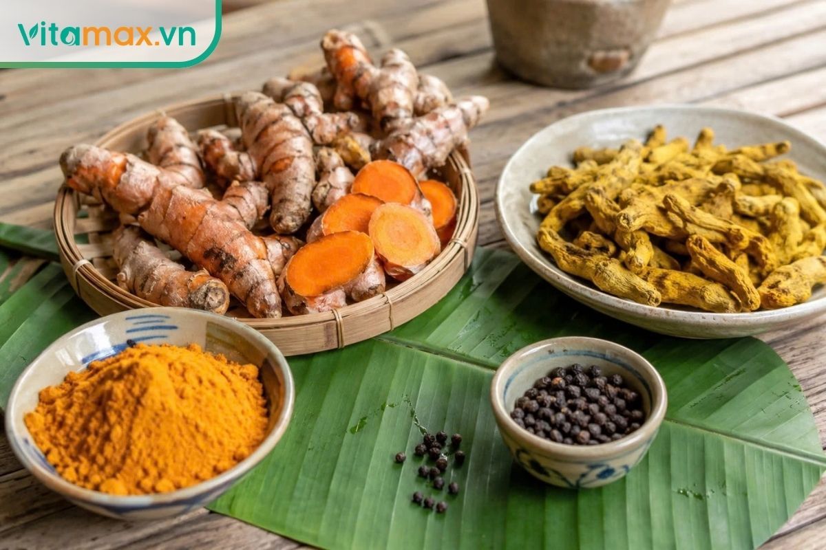 Nghệ tươi cắt lát, nghệ khô và bột nghệ đặt trên bàn gỗ, minh họa các dạng nguyên liệu từ thân rễ nghệ.