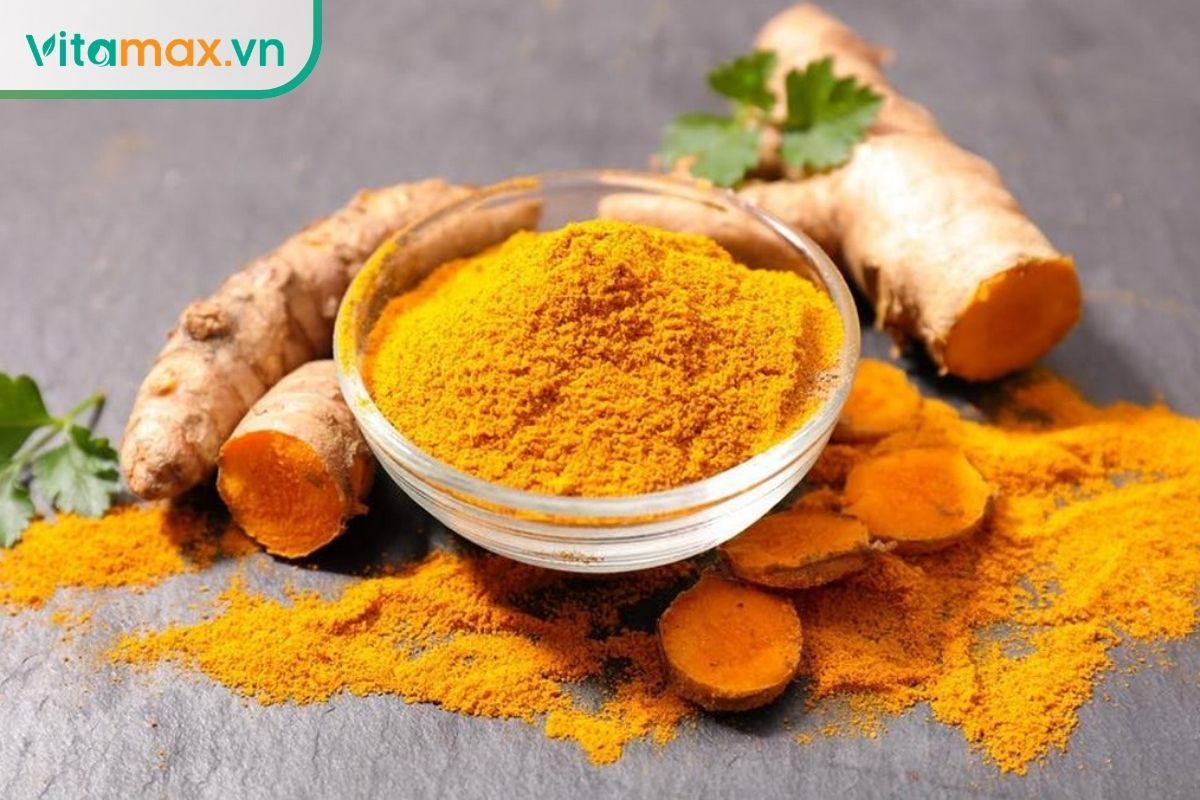 Củ nghệ tươi, nghệ thái lát và bột nghệ vàng trong bát thủy tinh.