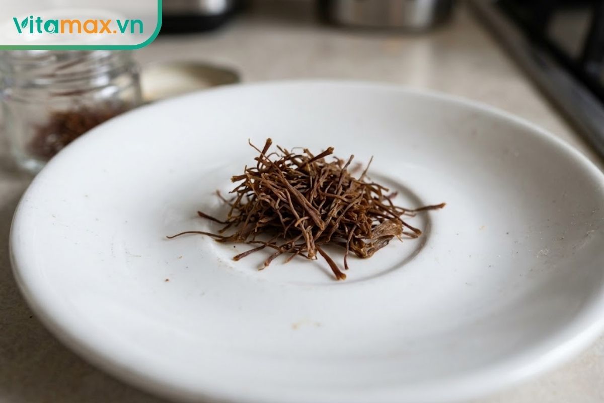 Cận cảnh các sợi saffron bị ẩm, mất đi độ giòn tơi tự nhiên, bết dính và vón cục lại với nhau trên đĩa trắng.