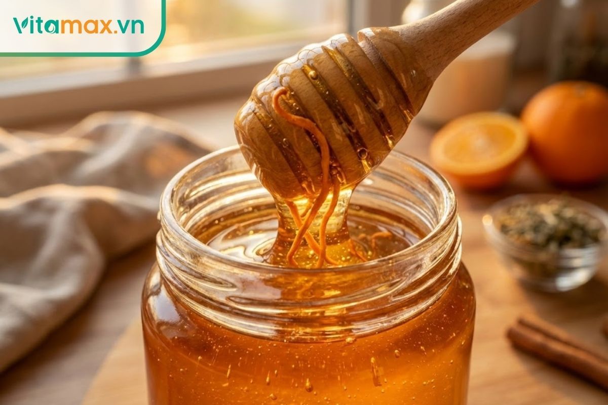 Hũ thủy tinh chứa nhộng trùng thảo ngâm trong mật ong nguyên chất, màu sắc vàng óng ánh.