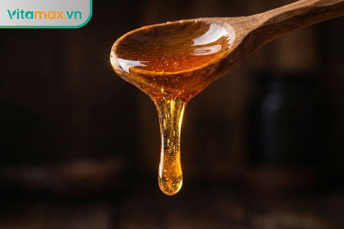 So sánh độ sánh và màu sắc của mật ong rừng nguyên chất khi được rót chậm từ thìa gỗ.