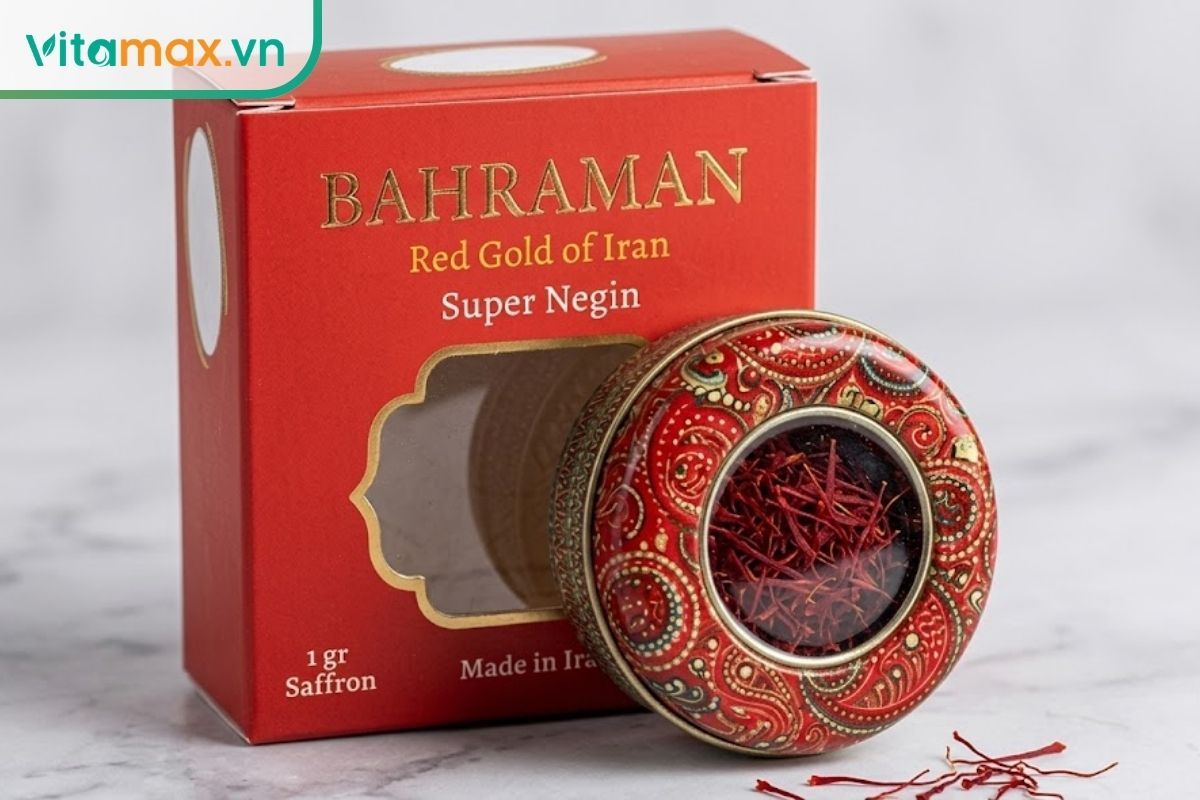 Một lọ thủy tinh nhỏ nắp vàng chứa đầy nhụy hoa nghệ tây đỏ sẫm, đặt trên bàn cạnh một hộp quà thắt nơ tinh tế.