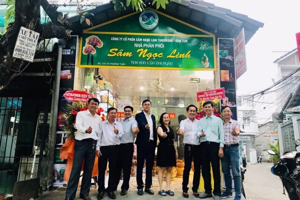 Tập thể lãnh đạo và khách hàng chụp ảnh kỷ niệm trước bảng hiệu cửa hàng sâm Ngọc Linh Tu Mơ Rông chi nhánh chính hãng