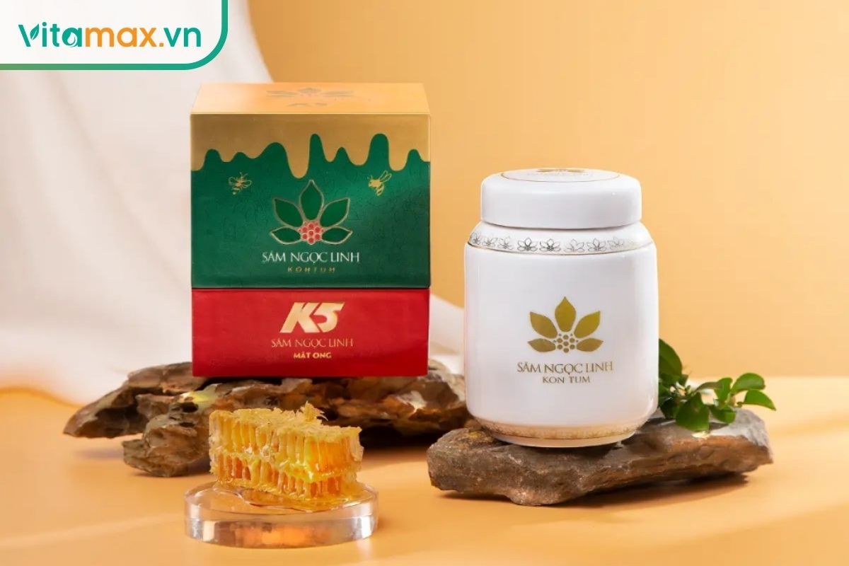 Hộp sản phẩm sâm Ngọc Linh K5 ngâm mật ong hai màu, lọ sứ trắng K5 và tổ ong tươi trưng bày chuyên nghiệp trên trang Vitamax.vn.