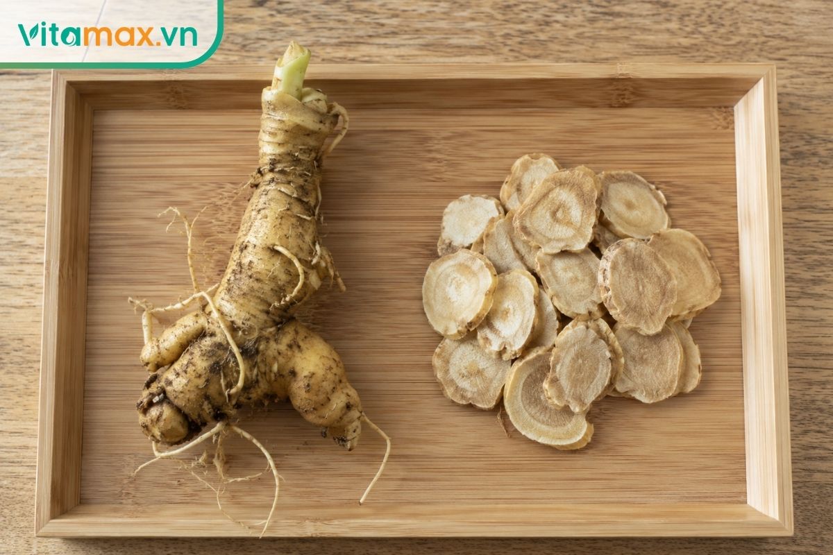 So sánh trực quan giữa một củ sâm nguyên vẹn và các lát sâm khô được thái mỏng đặt trên khay tre, chuẩn bị để ngâm rượu.