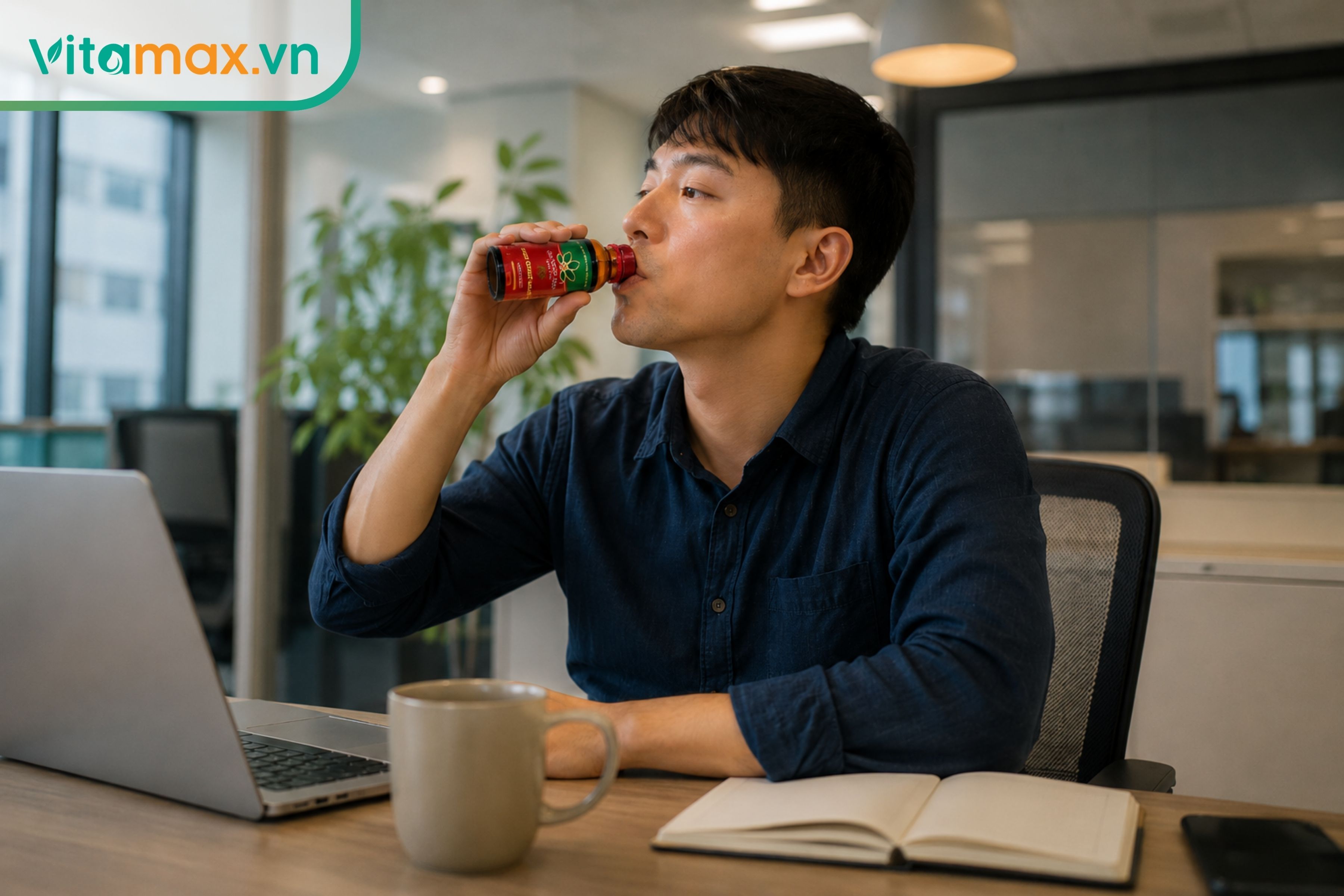 Nam nhân viên văn phòng đang sử dụng dịch chiết sâm Ngọc Linh trực tiếp từ lọ nhỏ tại bàn làm việc.
