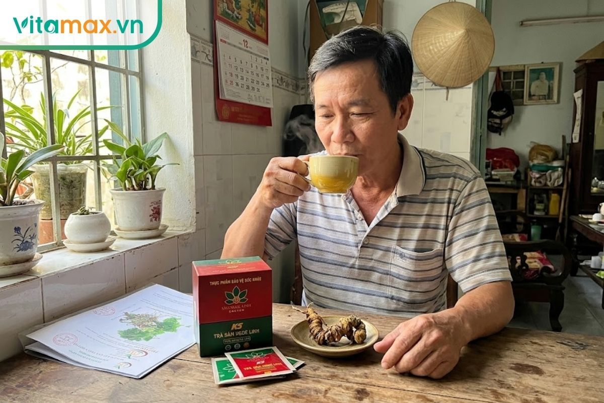 Một người đàn ông trung niên đang uống trà sâm Ngọc Linh vào buổi sáng sớm tại phòng khách ngập ánh nắng.