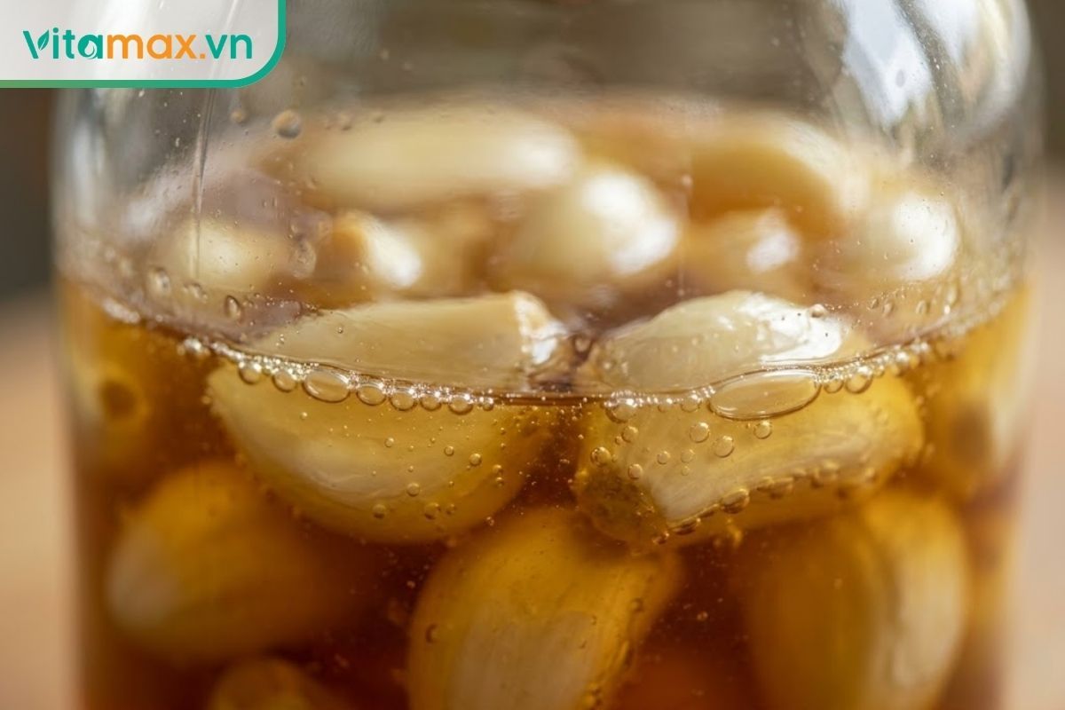 Cận cảnh bề mặt hũ tỏi ngâm mật ong xuất hiện các bọt khí nhỏ li ti bao quanh tép tỏi do quá trình lên men.