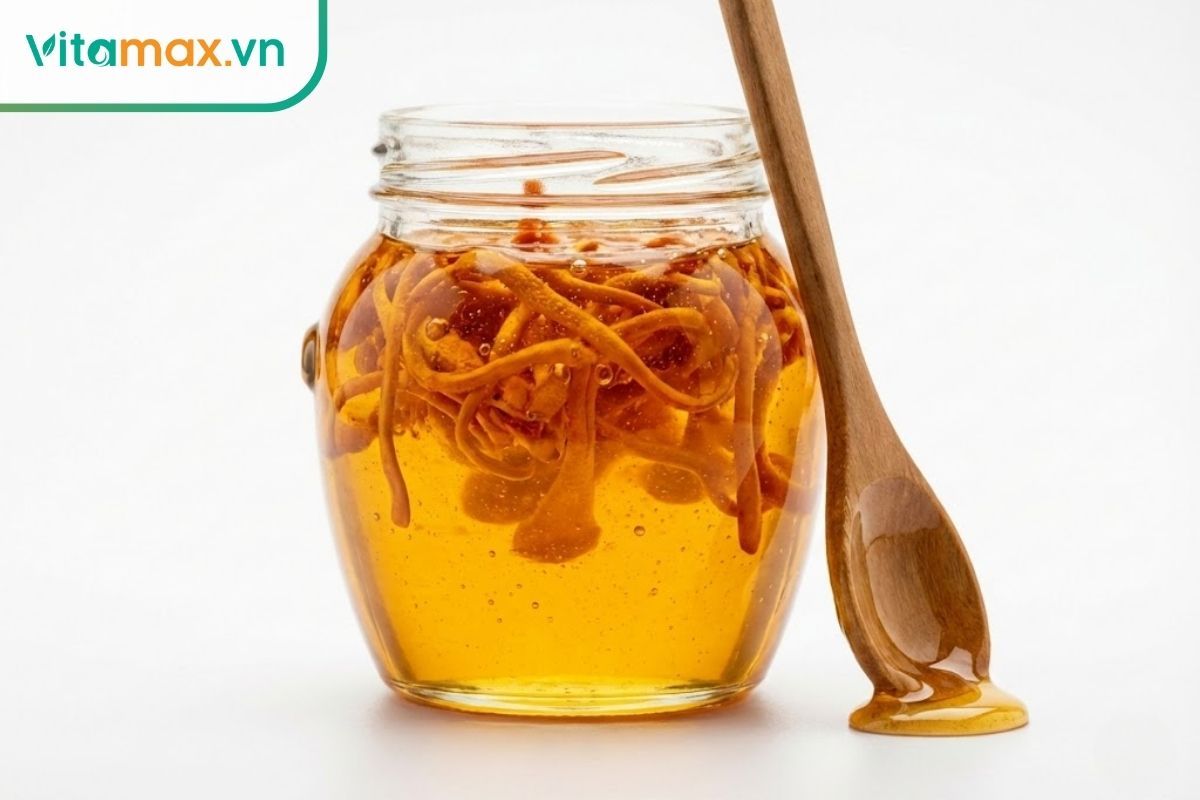 Cận cảnh hũ thủy tinh mật ong ngâm đông trùng hạ thảo, các sợi nấm nổi lơ lửng trong mật vàng óng.