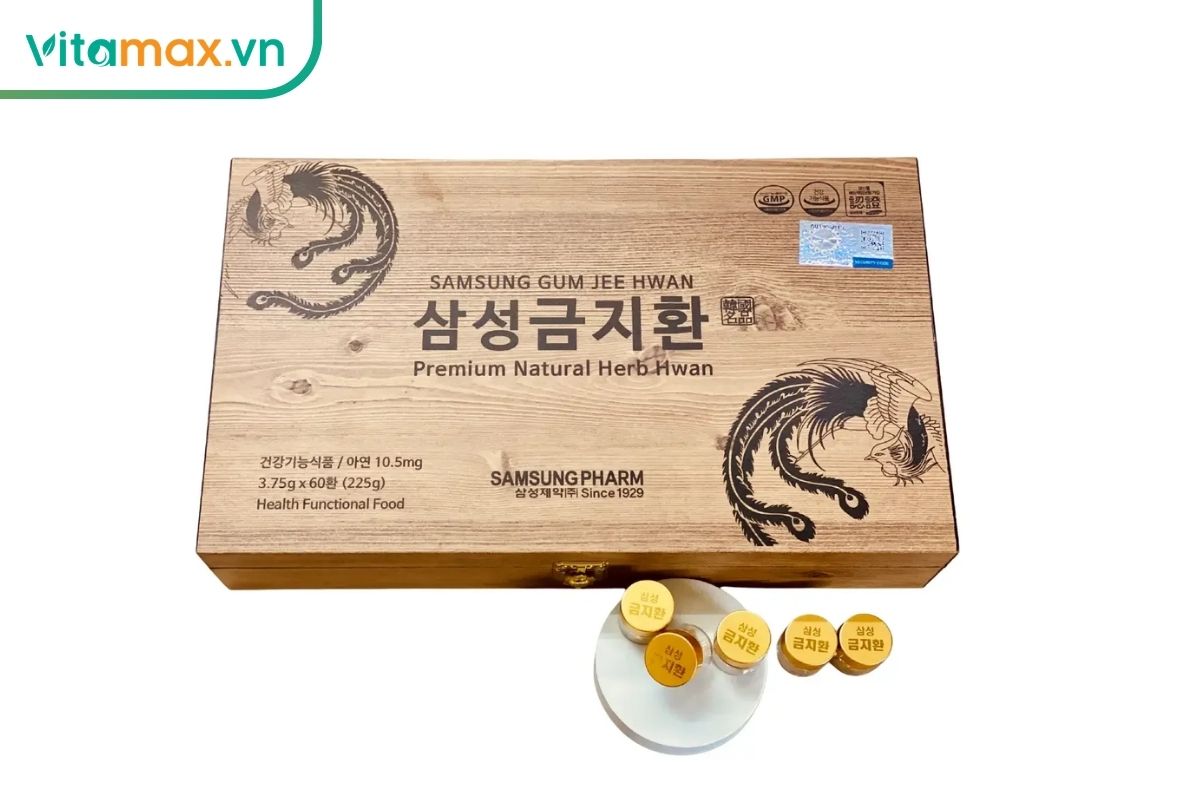 Hộp gỗ Samsung Gum Jee Hwang có họa tiết truyền thống Hàn Quốc, phía trước đặt các viên hoàn bọc vàng trên đĩa trắng.